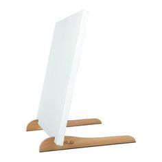 a white computer monitor sitting on top of a wooden stand