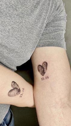 two tattoos on the arms of people that are both showing their date and heart shapes