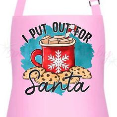 a pink apron that says, i put out for santa with cookies and a mug