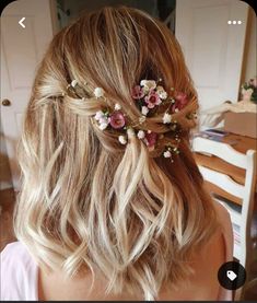 a woman with blonde hair and flowers in her hair is looking back at the camera