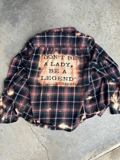 a plaid shirt that says don't be a lady, be a legend