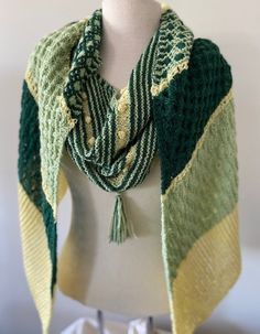 This green and yellow wrap is fun with lots of interesting stitches.  It is 94 inches long by 14 inches wide and can be wrapped in many different ways - limited only by your imagination.  It is a cotton blend and can be worn any time of the year.  Is can be washed (delicate) but  would be better to hand wash and dry flat. Green Crochet Shawl For Winter, Green Bohemian Shawl Wrap, Green Bohemian Scarf Wrap, Green Bohemian Wrap Scarf, Green Knitted One-size Scarves, Green Knitted Scarf One Size, Green Hand Knitted Shawl For Winter, Handmade Green Shawl For Winter, One Size Green Crochet Shawl