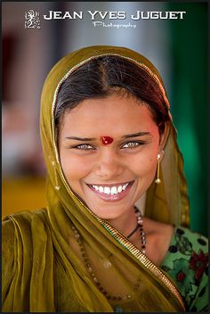 a woman wearing a headscarf and smiling for the camera