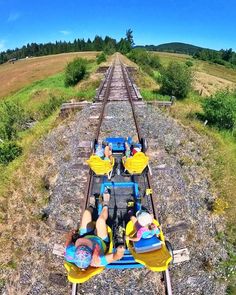 two people laying down on top of a train track