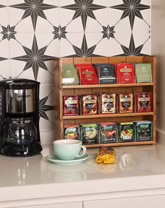 a coffee maker sitting on top of a counter next to a cup and saucer