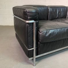 a black leather chair sitting on top of a cement floor