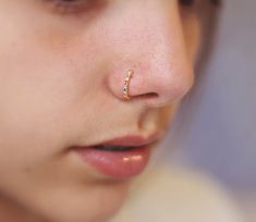 a close up of a child's nose with a tiny gold nose ring on it