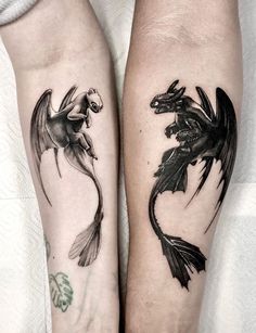 two black and white dragon tattoos on both forearms, one with an animal in the middle