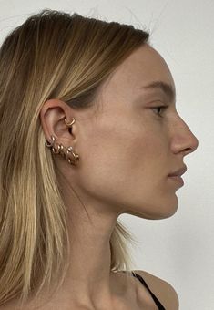 a woman with ear piercings on her left side and right half of her face