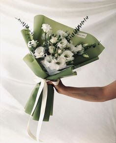 a person holding a bouquet of white flowers