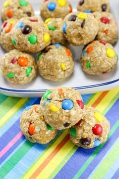 cookies and candy balls on a plate next to a colorful table cloth