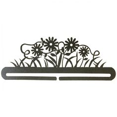 a metal sign with flowers on it in the shape of a flower pot and some grass