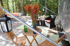 an outdoor patio with chairs, table and flowers