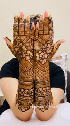 a woman with her hands covered in henna