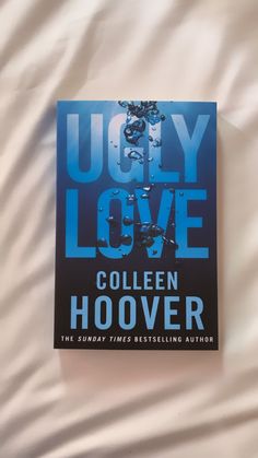 the book ugly love by collien hoover is laying on a white sheet