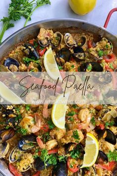 seafood paella in a pan with lemon wedges and parsley on the side