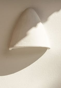 the corner of a white wall with a light coming from it's center point