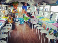 the inside of a bus with many tables and stools on each side of it