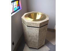 a toilet with a gold bowl on it in front of a stained glass window and checkered floor