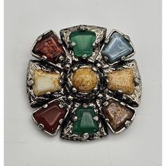 Add a touch of vintage elegance to your attire with this beautiful brooch pin from the Celtic brand. Made of silver tone metal, it features a stunning cabochon glass jewel in a multicolor shade. The unique shape of the brooch with a cross motif adds an extra charm to it.  Crafted with utmost care, this original piece of vintage jewelry is perfect for fashion-conscious individuals. With no signs of wear and tear, this brooch pin is a must-have for collectors and enthusiasts alike. Suitable for bo Vintage Multicolor Cabochon Jewelry, Multicolor Cabochon Brooch For Gift, Multicolor Cabochon Brooches For Collectors, Multicolor Cabochon Brooch As Gift, Multicolor Cabochon Brooches For Gifts, Multicolor Cabochon Brooches As Gift, Vintage Multicolor Collectible Brooches, Unique Multicolor Cabochon Brooches, Vintage Silver Brooch With Gemstone