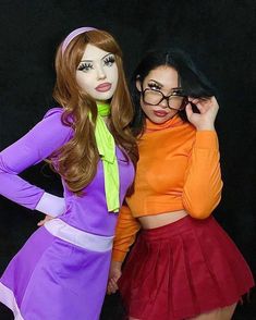 two women dressed up in costumes posing for a photo with one woman wearing glasses and the other holding her hair