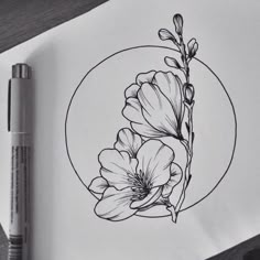 a drawing of flowers in a circle on top of a piece of paper next to a marker