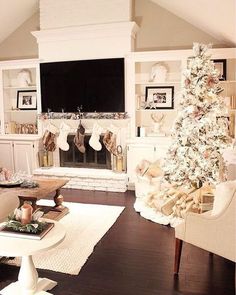 a living room with a christmas tree in the corner and stockings hanging from the fireplace