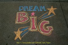 chalk drawing on the sidewalk that says dream big with stars and stripes in red, white, and blue