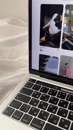 an open laptop computer sitting on top of a white bed covered in sheets and pillows