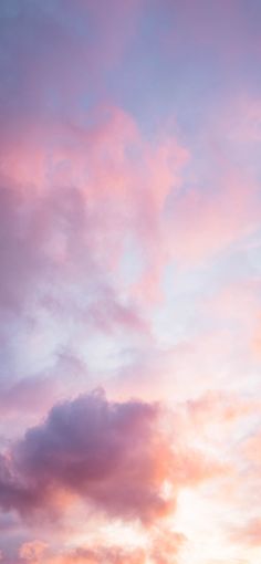 an airplane is flying in the sky with pink and blue clouds behind it at sunset