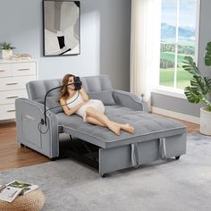 a woman laying on top of a couch in a living room