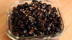 a glass bowl filled with raisins on top of a wooden table