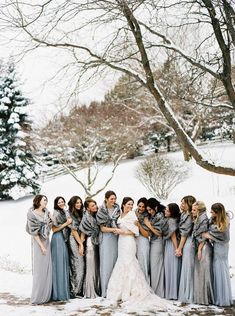 a group of women standing next to each other in front of a snow covered field