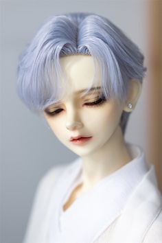 a close up of a doll wearing a white shirt and blue hair with her eyes closed