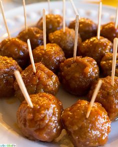 some meatballs are on a white plate with toothpicks