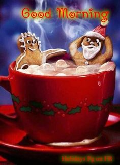 two gingerbread men sitting in a cup of hot chocolate with marshmallows