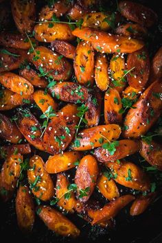 cooked carrots with sesame seeds and parsley in a skillet, ready to be eaten