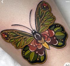 a colorful butterfly tattoo on the thigh