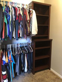 a closet filled with lots of clothes and ties hanging from it's walls next to a bookcase