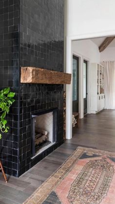 a living room with a fire place and rugs on the wooden floor next to it