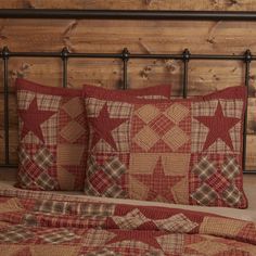 a bed topped with red and brown pillows next to a wooden headboard