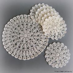 three crocheted doily are shown on a gray surface, one is white and the other is beige