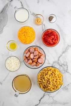 the ingredients to make this pasta dish are laid out on a marble counter top, ready to be mixed together