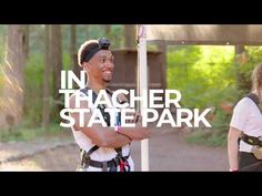 two people standing next to each other in front of a sign that says in thaacher state park