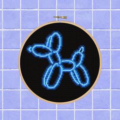 a cross stitch pattern on a black background with blue lights in the shape of a dog