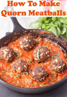 some meatballs are in a red sauce with parsley on the side and basil