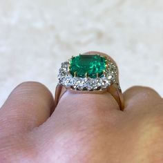 An impressive cluster ring that features a lively 4.55 carat natural Colombian emerald-cut emerald with a green saturation. Surrounding the center stone is a cluster of old European cut diamonds. This ring is crafted in platinum and 18k yellow gold.
The center emerald is GIA certified stating that it is a natural Colombian emerald weighing 4.55 carats and has minor oil treatment.
The total approximate weight of the diamonds is 1.50 carats.
This ring can be resized to any finger size at no extra Colombian Emerald Ring, European Cut Diamond Ring, Estate Diamond Jewelry, Columbian Emeralds, Gia Certificate, Emerald And Diamond Ring, Gemstone Engagement, Colombian Emeralds, 18k Yellow Gold Ring