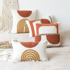 four decorative pillows on a white bed