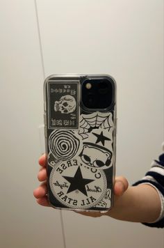 someone holding up their phone case with stickers on it