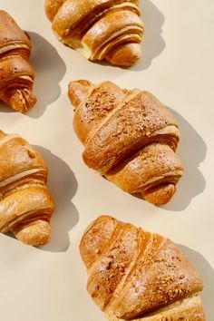 four croissants sitting on top of a white surface